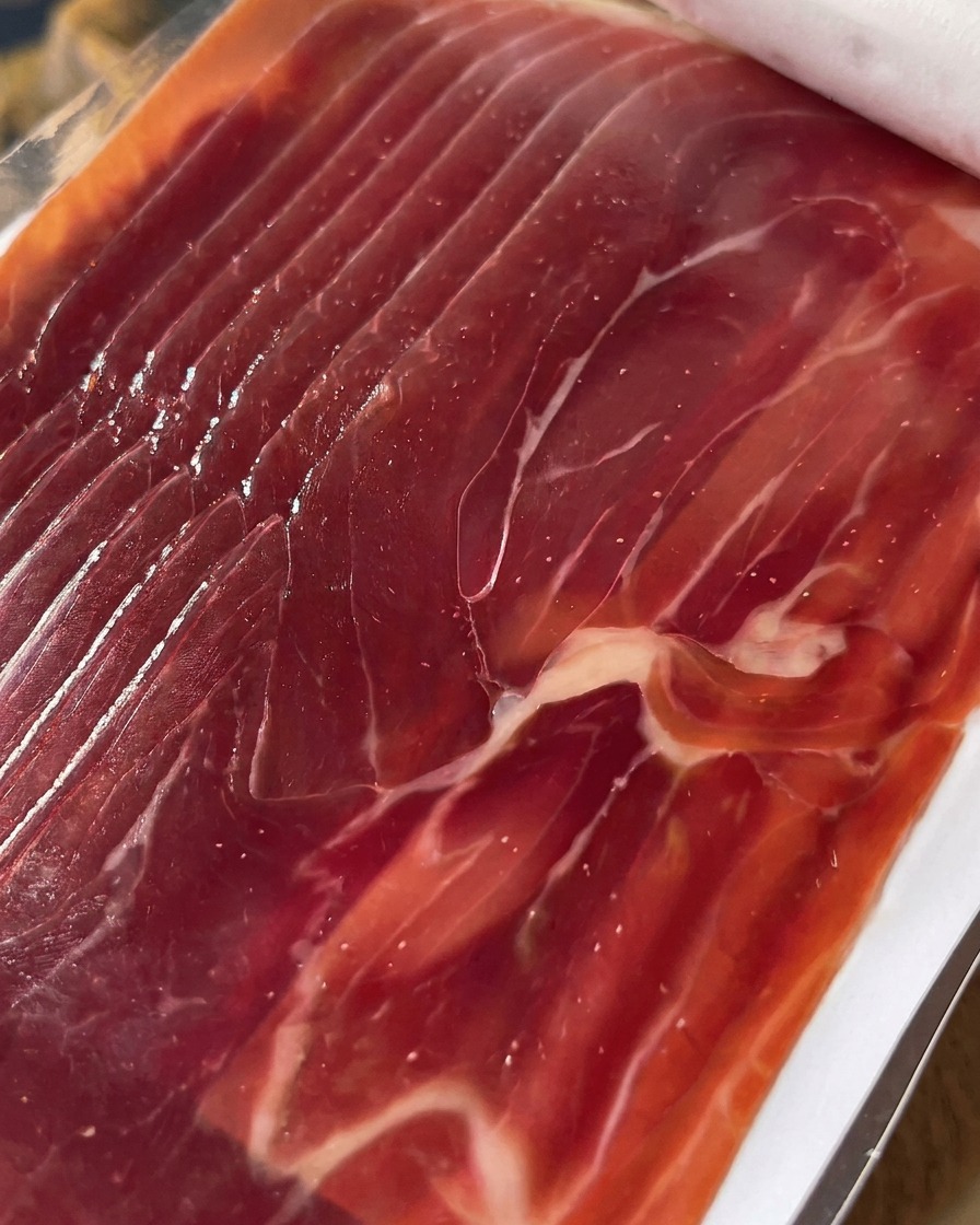 Primer plano de prosciutto cortado ordenadamente y listo para colocarse sobre los higos.
