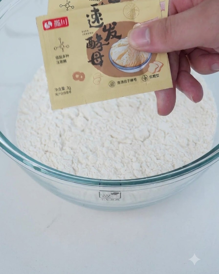 Ingredientes secos y húmedos, como harina y levadura, añadiéndose en un bol de mezcla transparente.