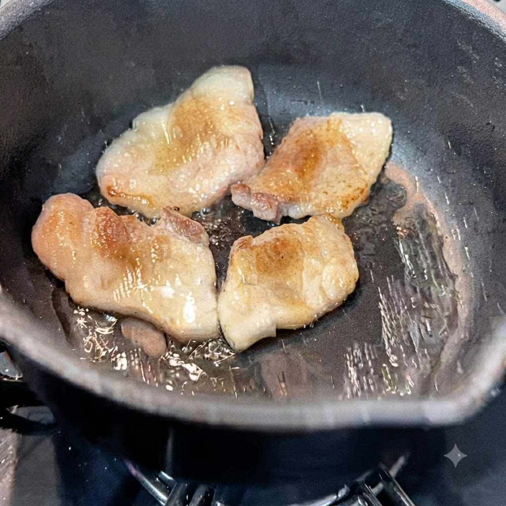 Agua siendo vertida en la olla caliente que contiene rebanadas de panceta de cerdo fritas.