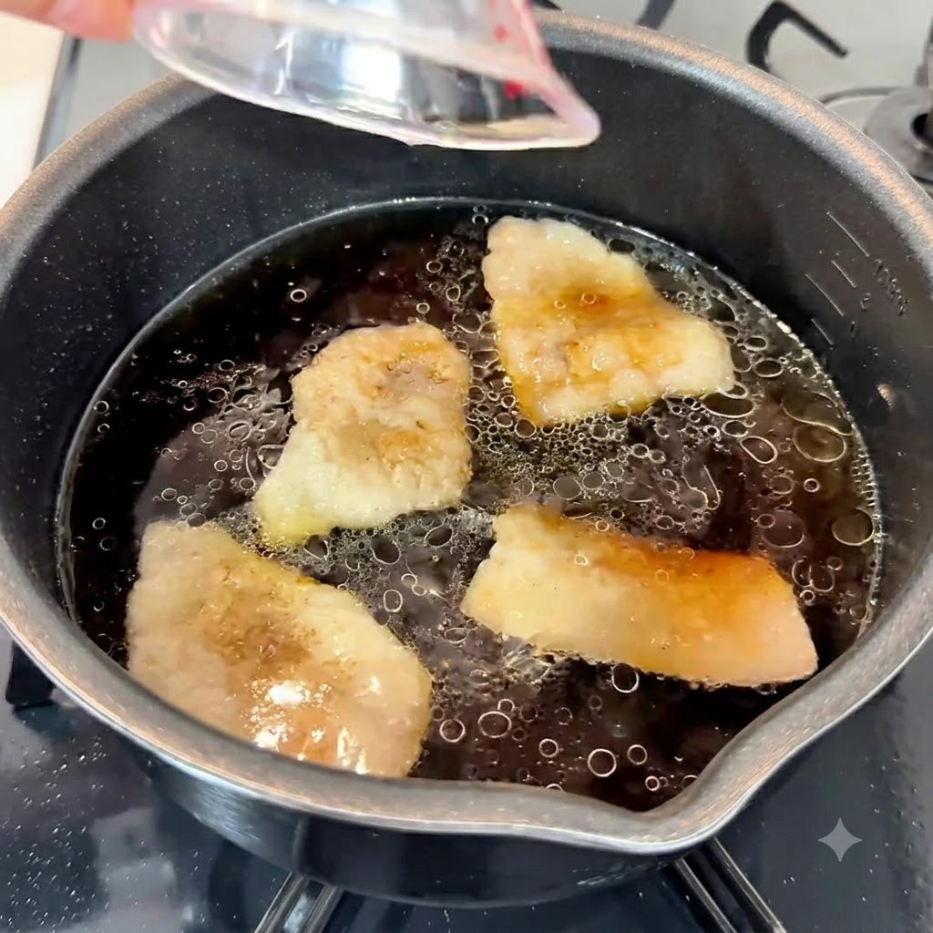 Pasta de ajo, aceite de sésamo y azúcar blanca siendo vertidos en la rica base de sopa sabrosa en una olla.