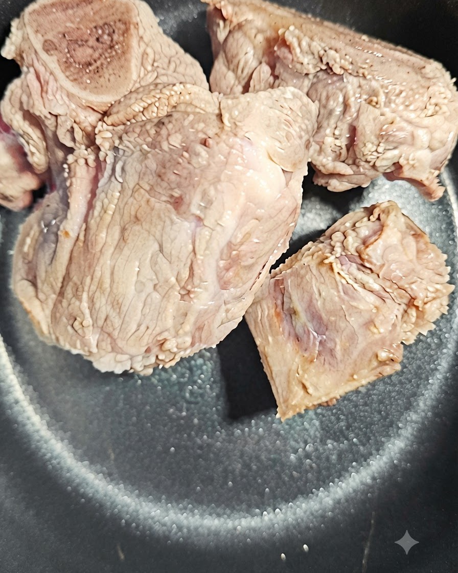 Una rodaja de raíz de angélica colocada junto a los huesos de cerdo en la olla.