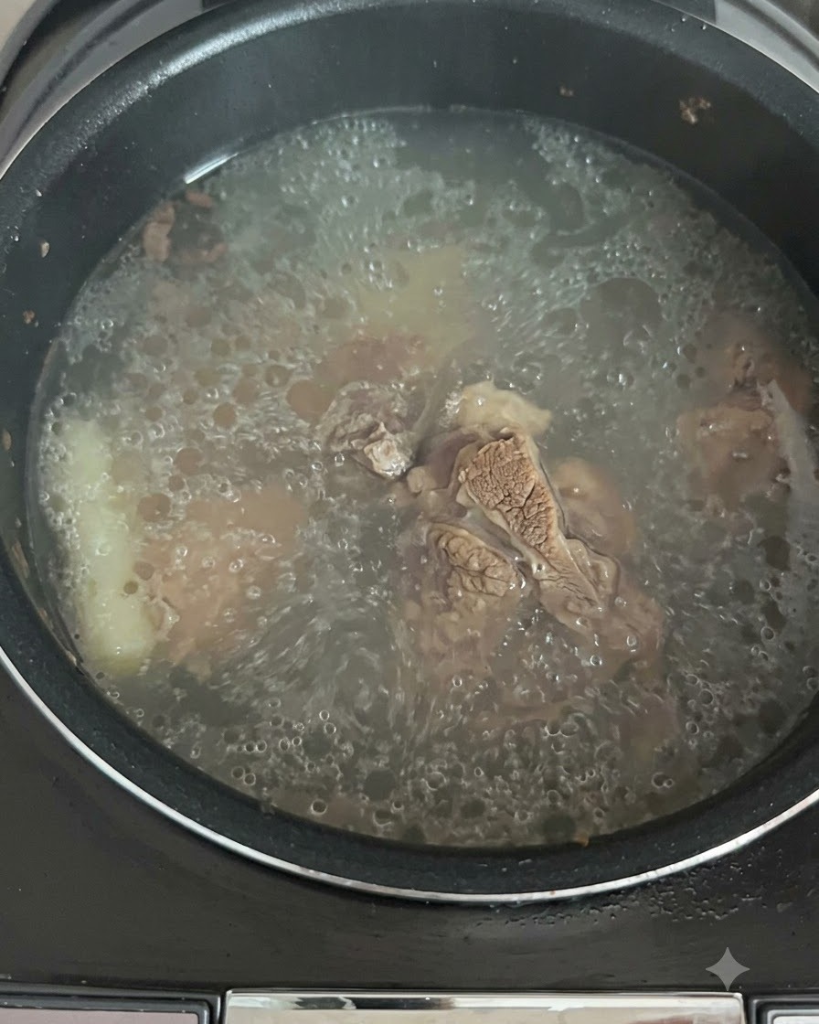 El caldo burbujeando y hirviendo activamente dentro de la olla de la arrocera.
