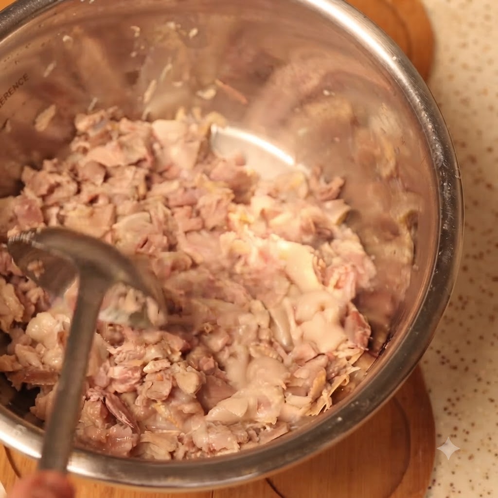 Carne de cerdo cocida triturándose a fondo en un tazón grande para mezclar.
