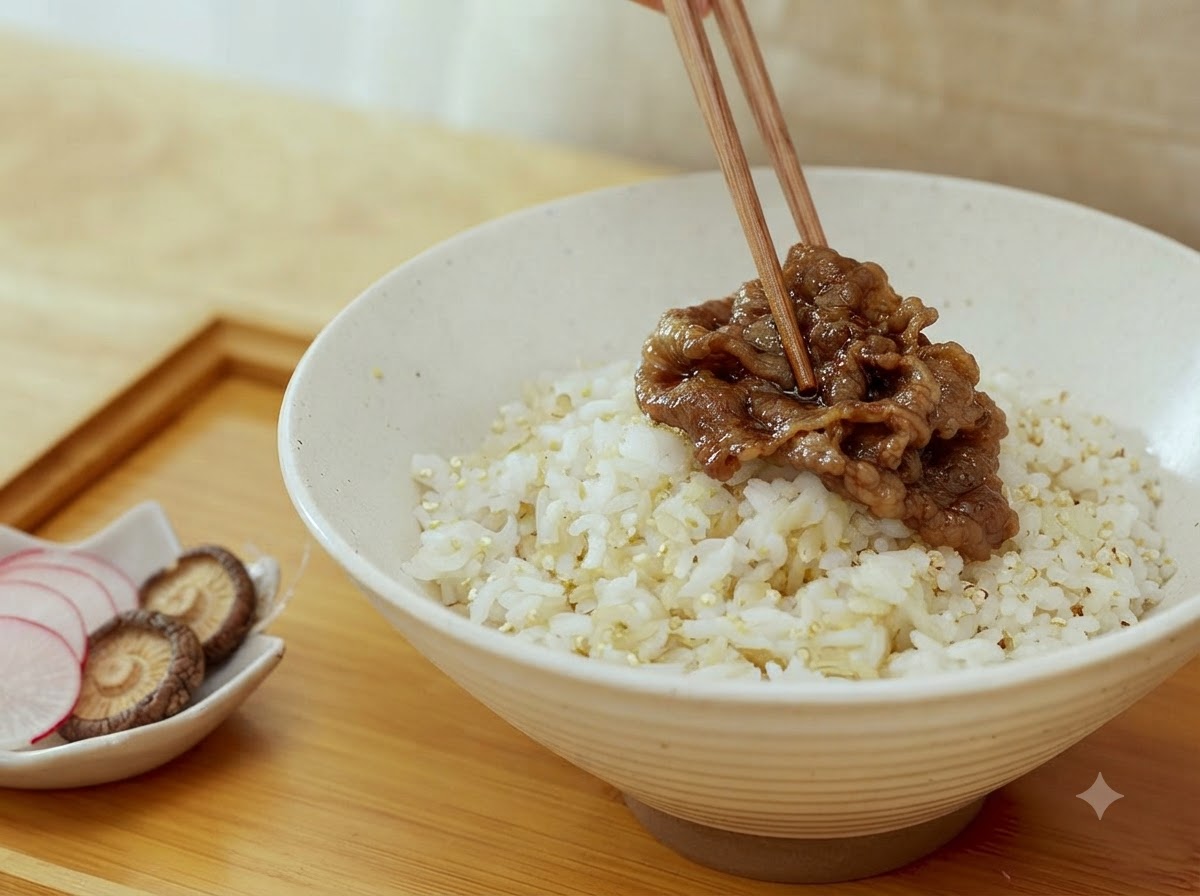 Un par de palillos colocando rodajas de carne cocida sobre un tazón de arroz cocido.