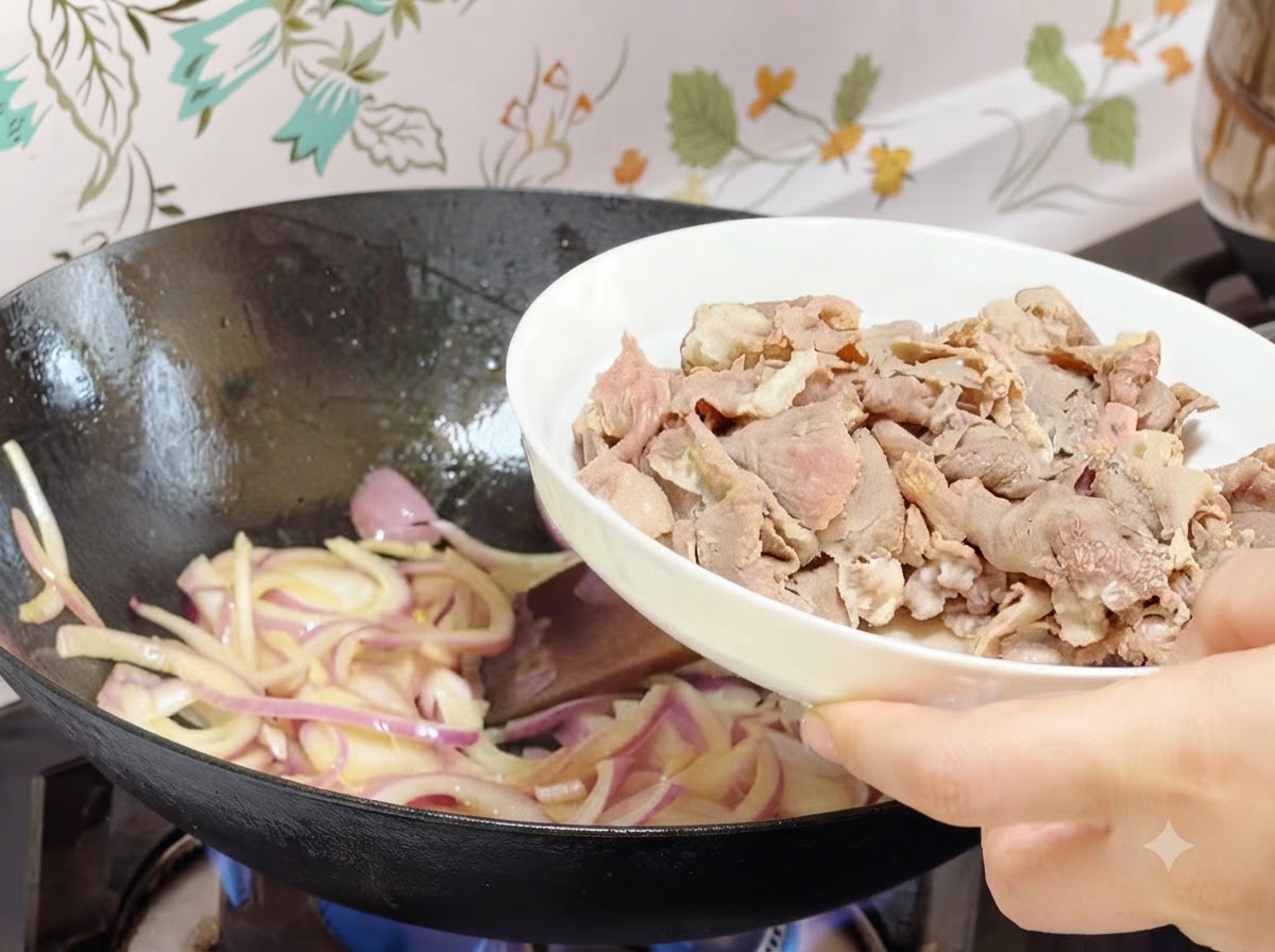 Rollitos de ternera preblanqueados siendo vertidos desde un plato blanco hacia el wok con cebollas cocinadas.