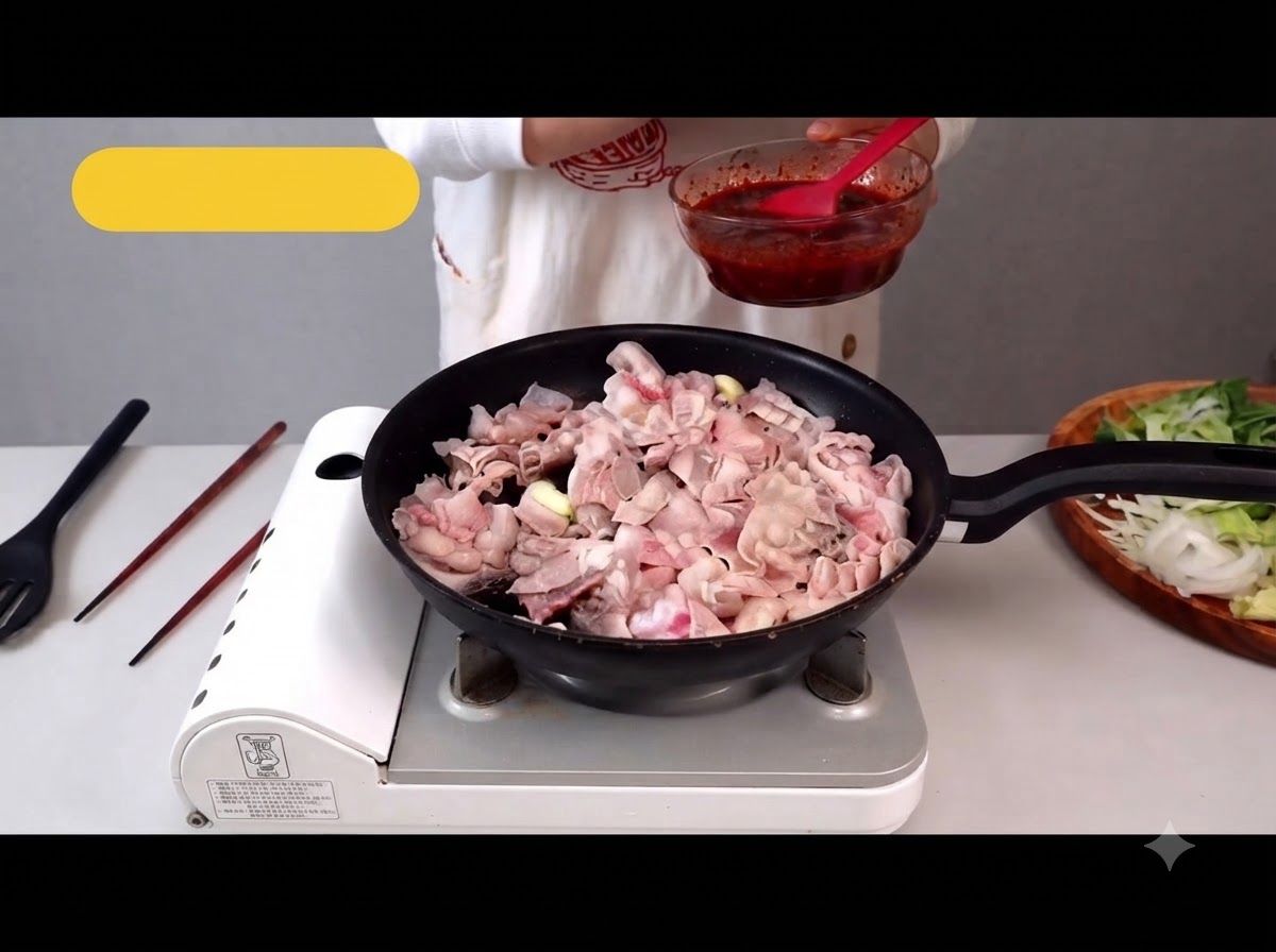 Panceta de cerdo en rodajas finas cocinándose en una sartén, soltando su grasa.
