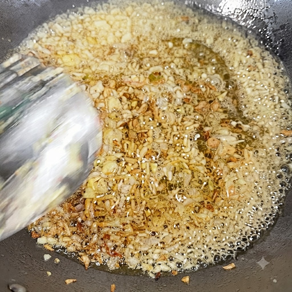 Ajo picado y cebolla en dados friéndose en aceite caliente en un wok.