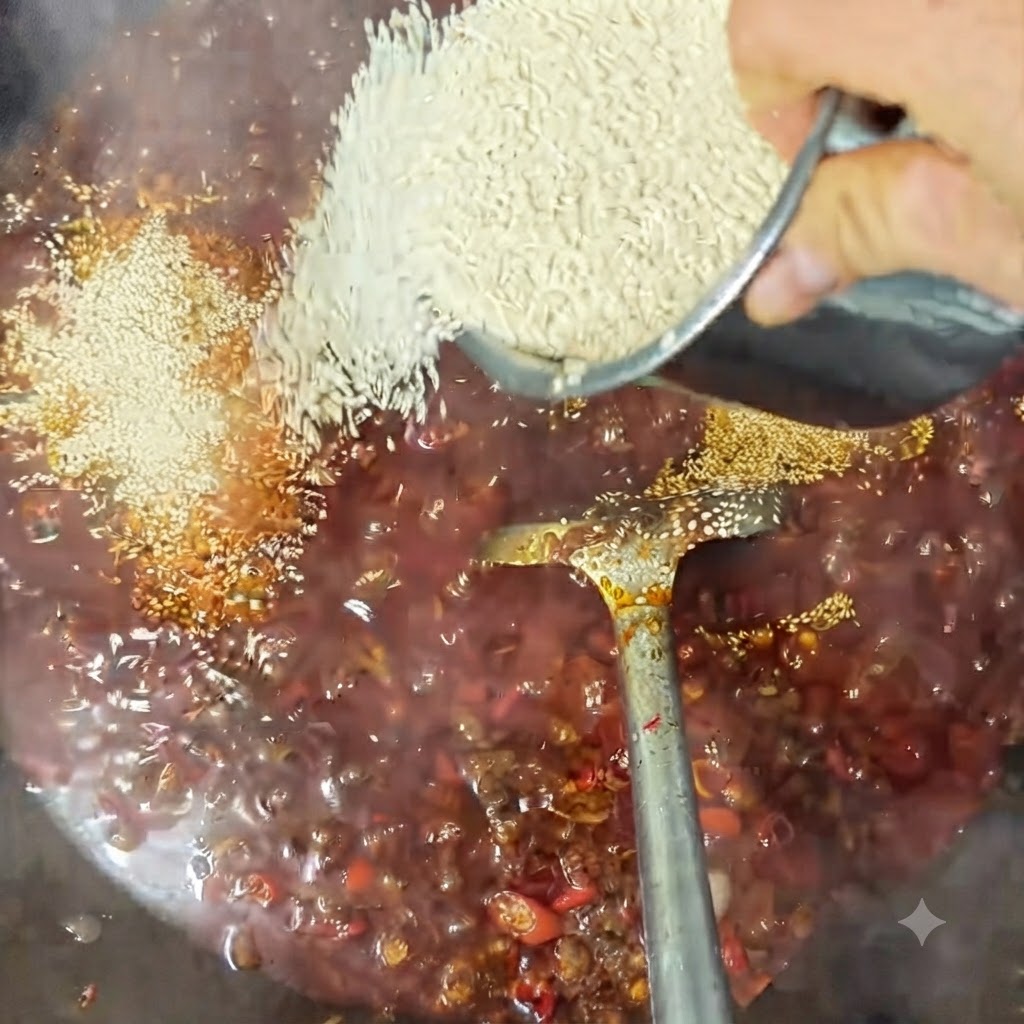 Semillas de sésamo blanco siendo esparcidas sobre la salsa burbujeante en un wok.