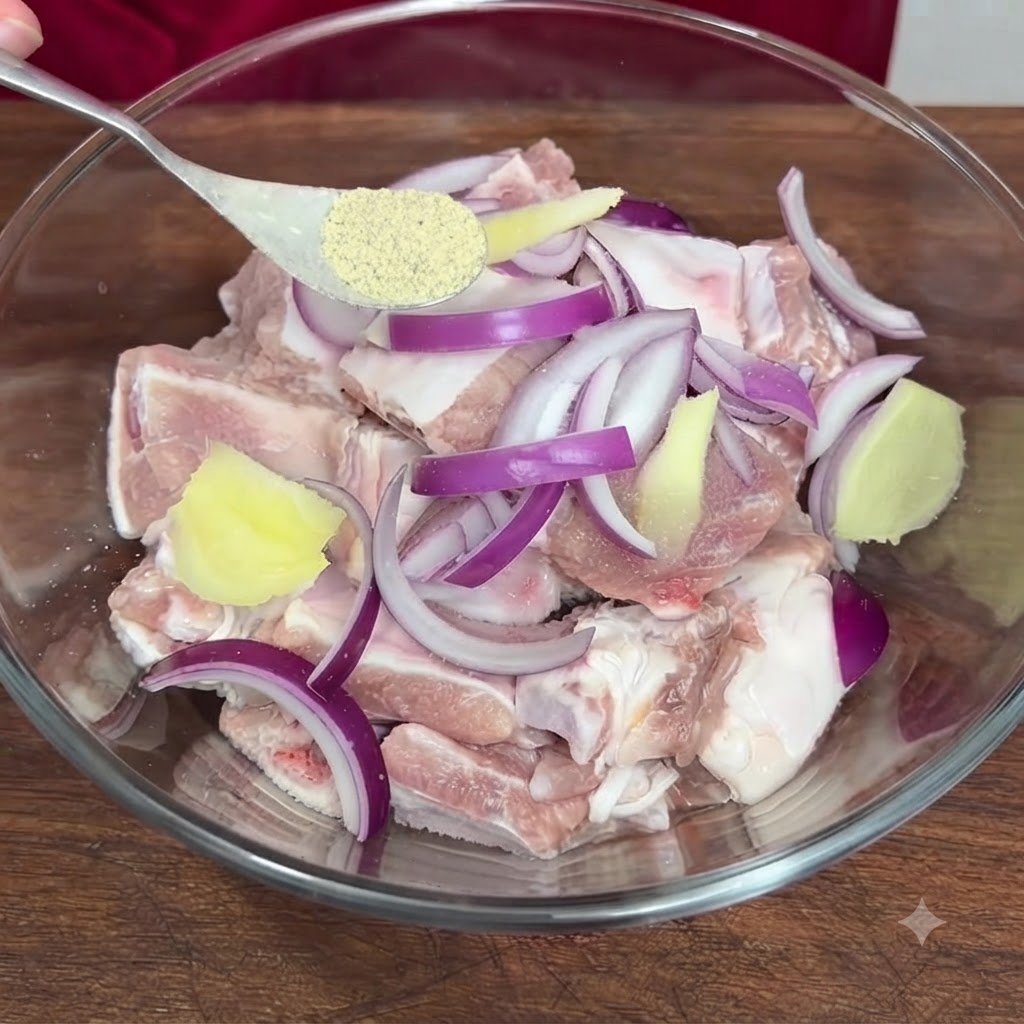 Una cuchara con pimienta en polvo siendo añadida al tazón que contiene las costillas de cerdo sazonadas.