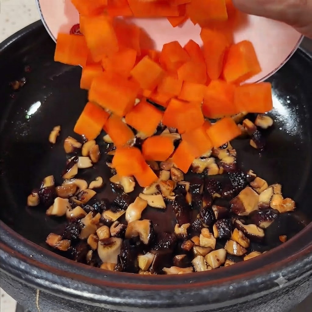 Zanahorias en cubos de color naranja brillante siendo vertidas desde un plato hacia la olla que contiene las setas salteadas.