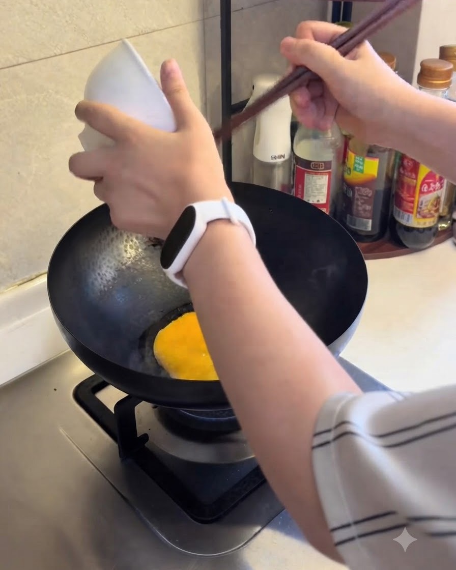 Huevo batido siendo vertido en una sartén caliente para cocinar.