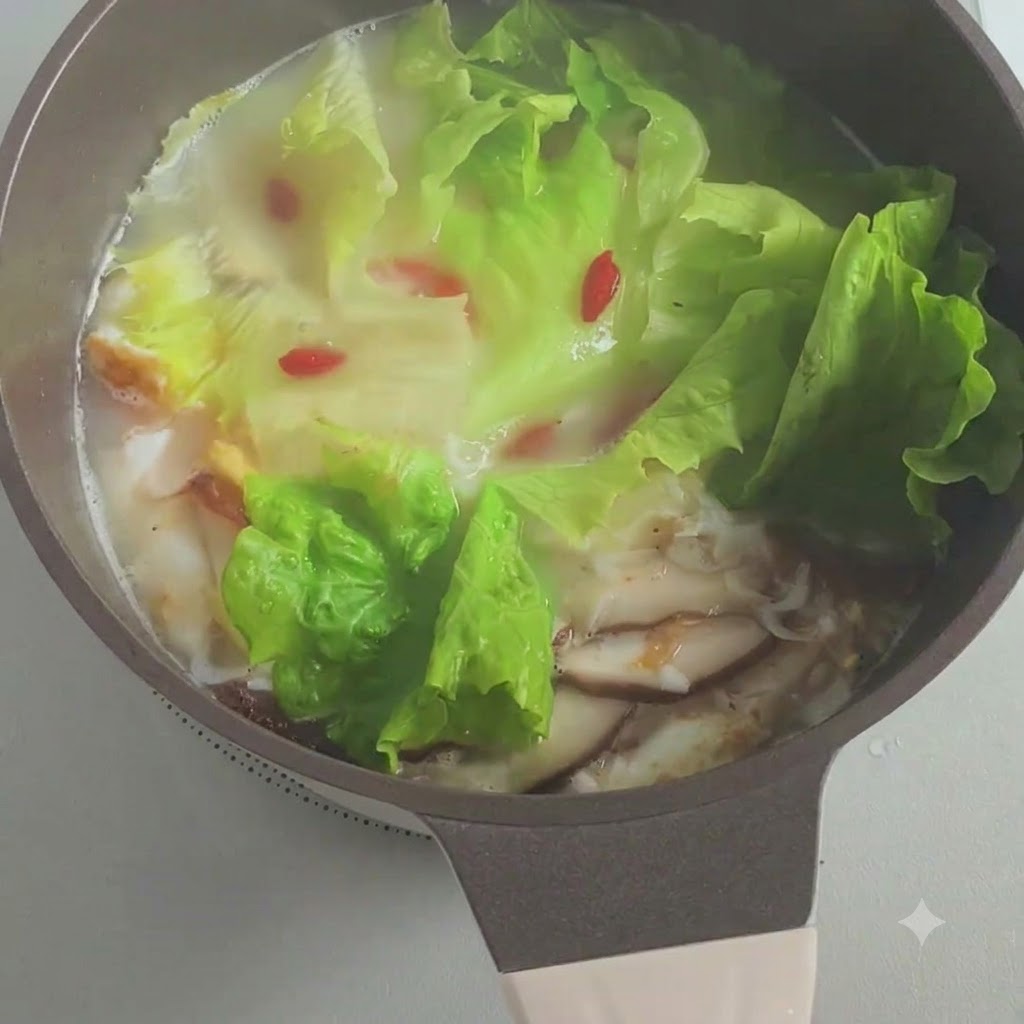 Cebolletas picadas siendo espolvoreadas en la olla de sopa a fuego lento.