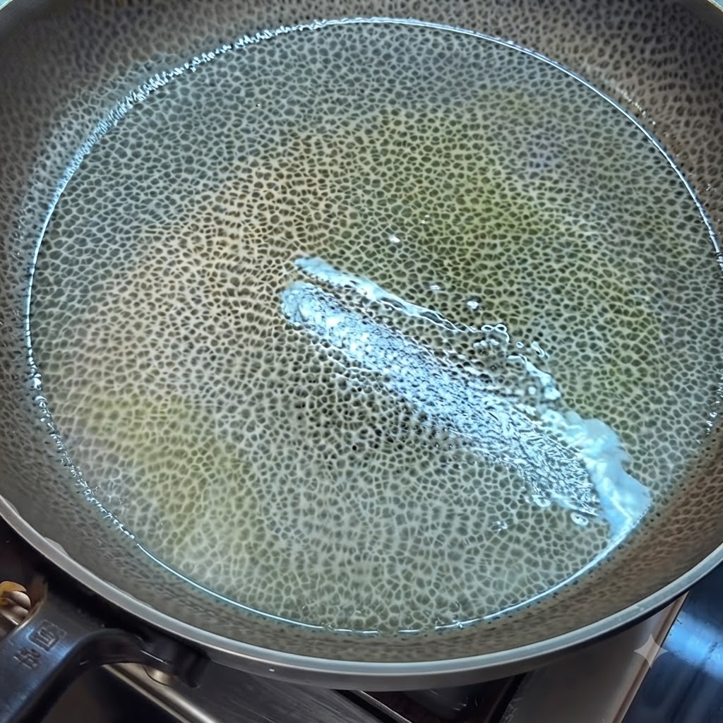 Huevo batido cocinándose y revolviéndose en una sartén engrasada con una espátula.
