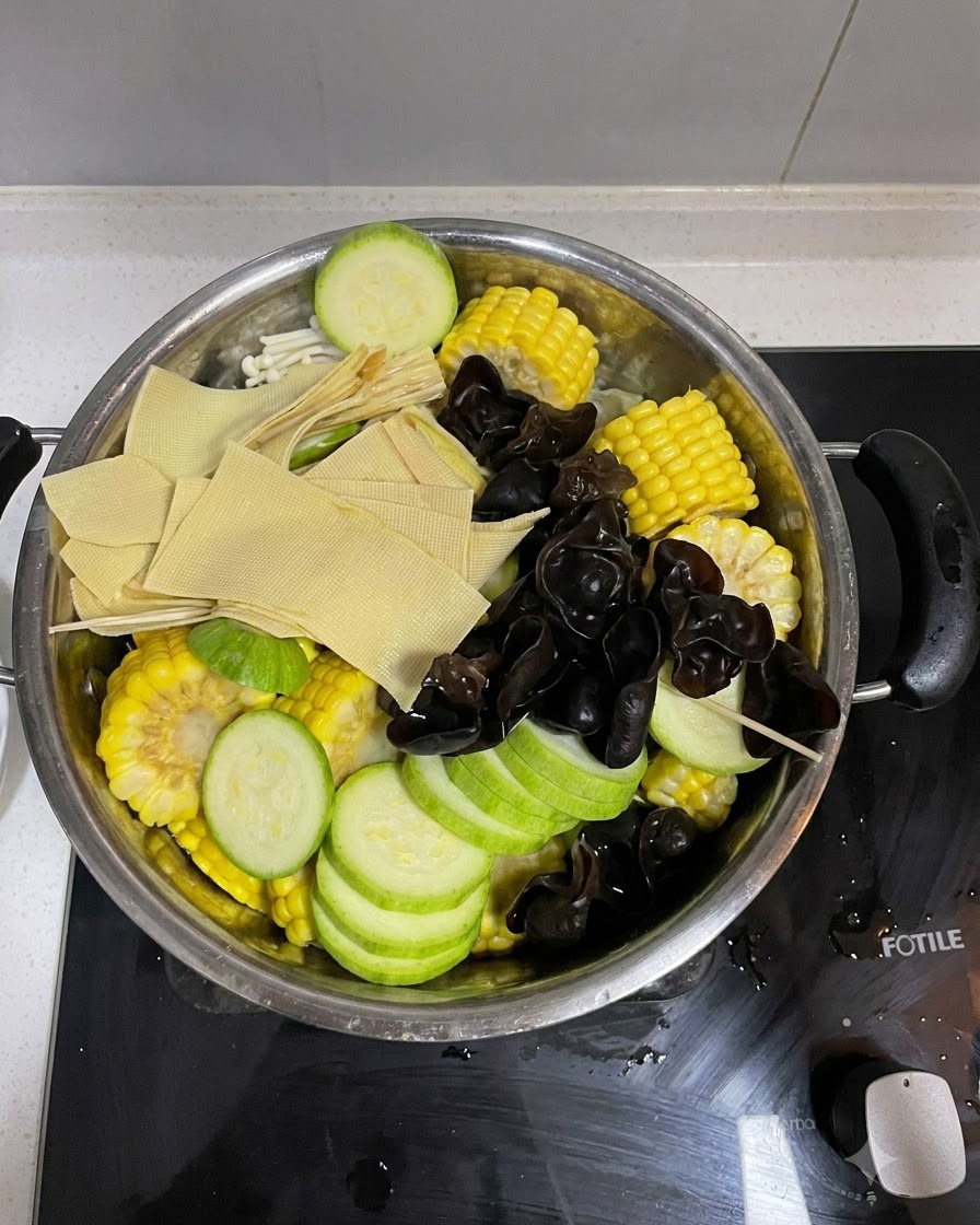 Verduras ensambladas con kimchi colocado encima dentro de la olla de cocina.