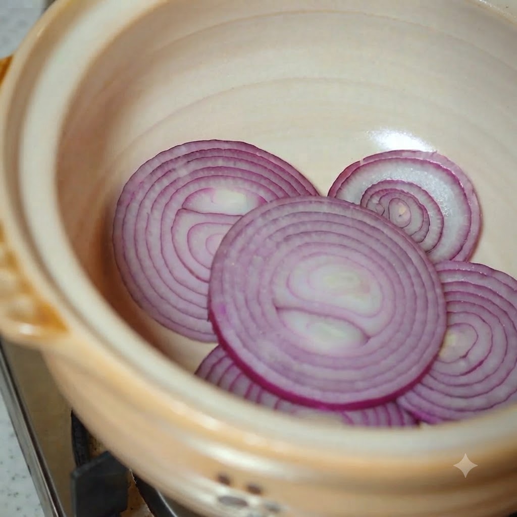 Col napa y calabacín en rodajas siendo añadidos a la olla de barro.