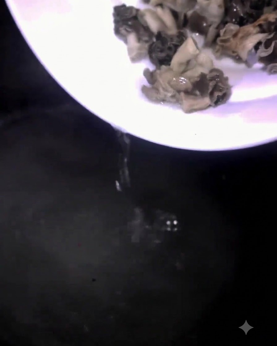 Setas vertidas desde un plato blanco a una olla con agua hirviendo.