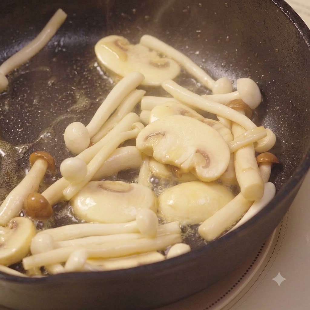 Ajo picado mezclado con los hongos en proceso de fritura y removido con una espátula.