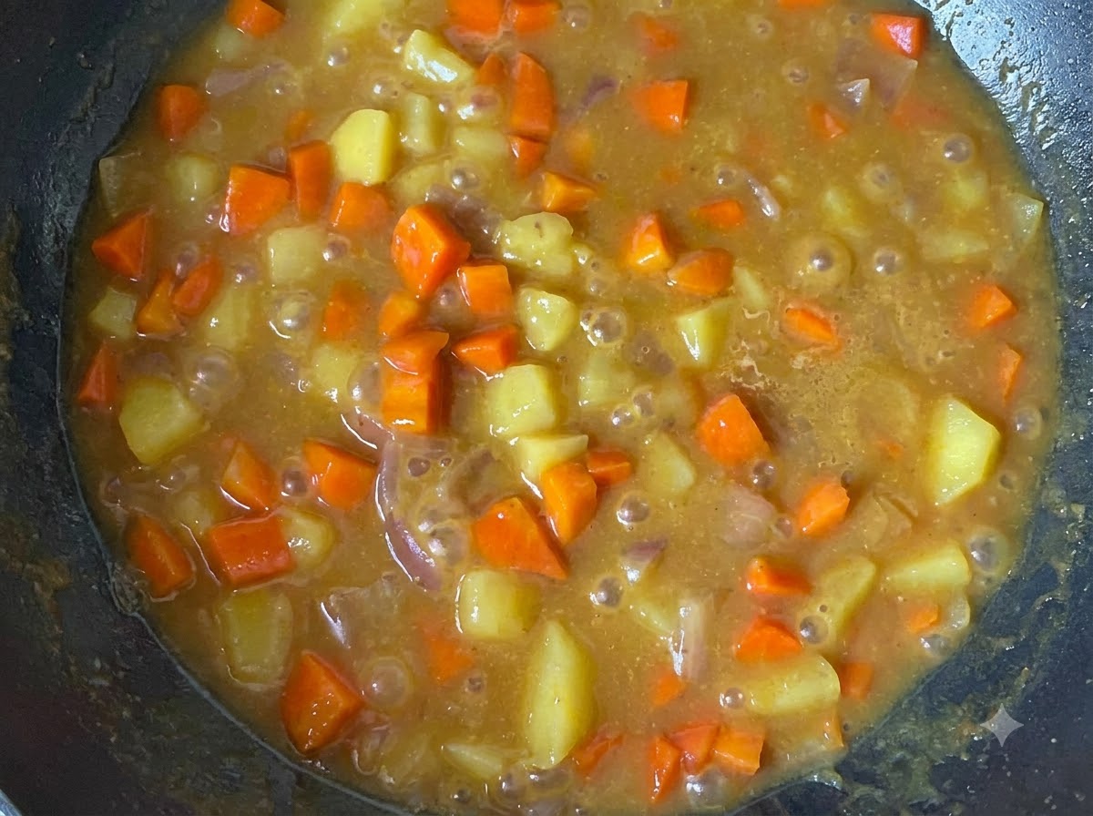 Salsa de curry de estilo japonés espesa y sabrosa con trozos de patata y zanahoria sobre una cama de arroz blanco.