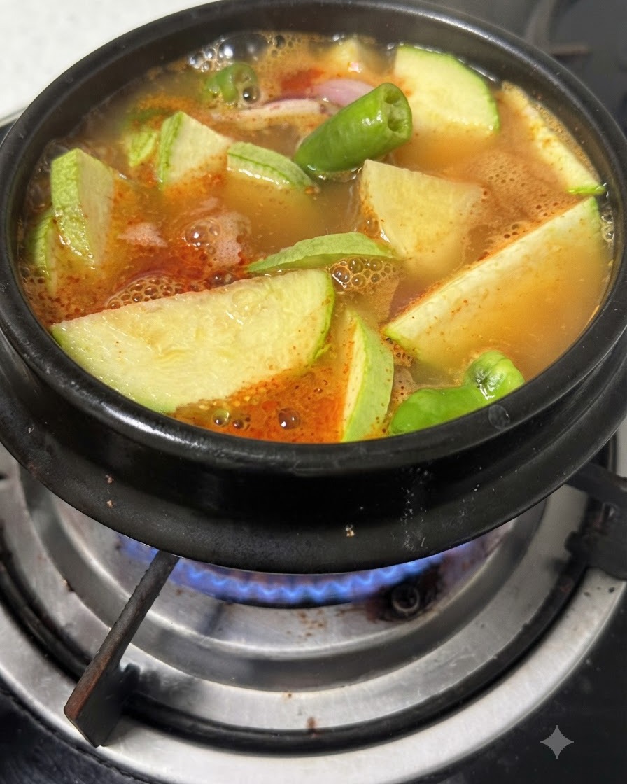 Tofu en cubos cociéndose a fuego lento en el caldo sazonado con calabacín y pimientos.