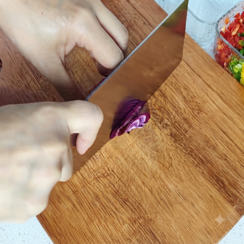Cortando una cebolla roja en cubitos pequeños sobre una tabla de cortar de madera.